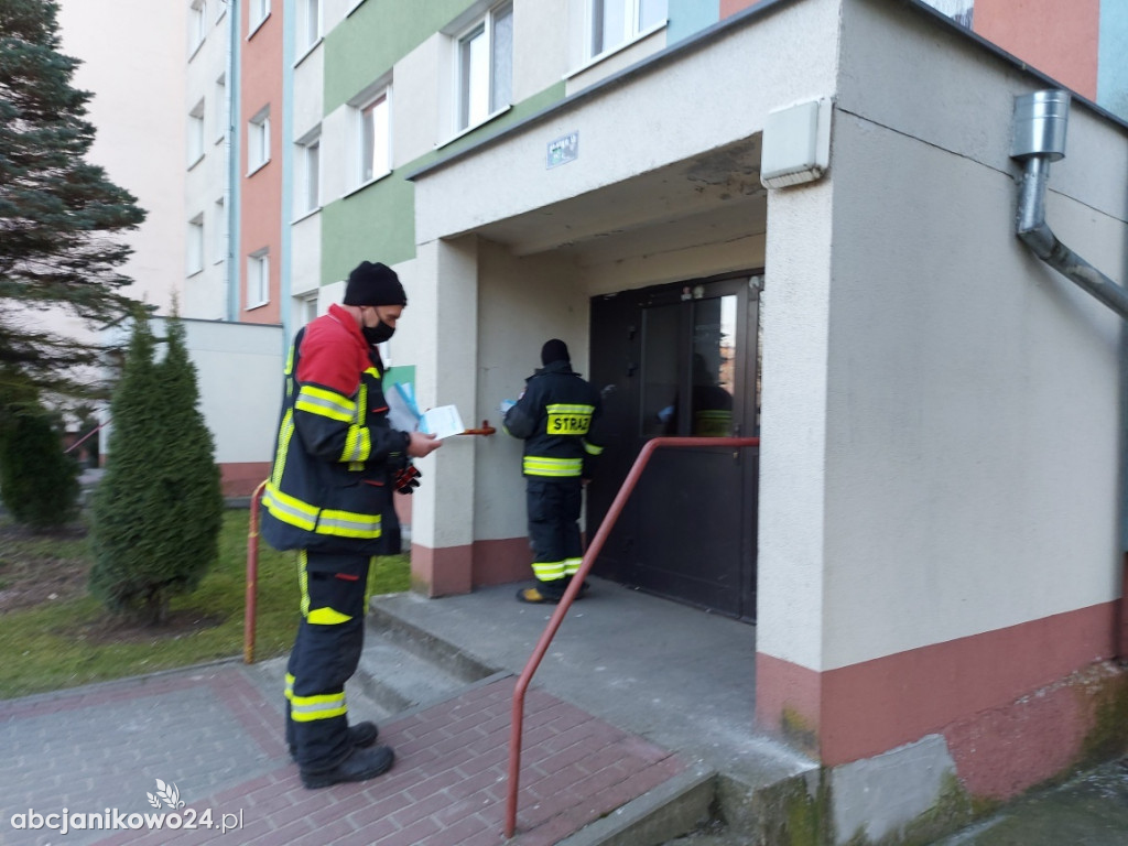 Strażacy dostarczają ulotki propagujące wiedzę na temat profilaktyki i szczepień przeciw COVID-19